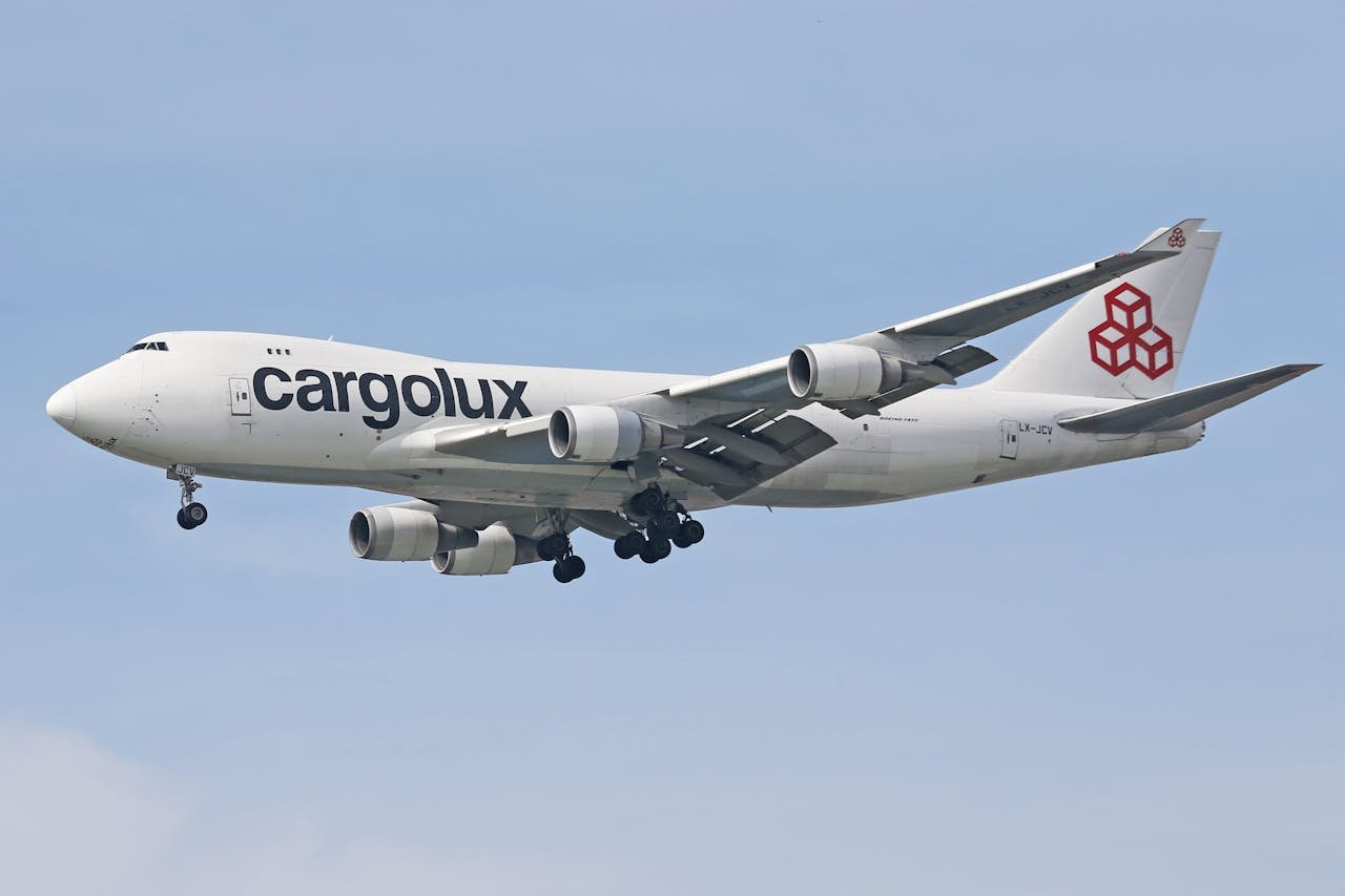 A Cargolux Boeing 747 cargo plane in flight under a clear blue sky.